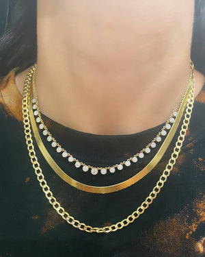 styled necklace stack with curb link chain herringbone chain and diamond choker